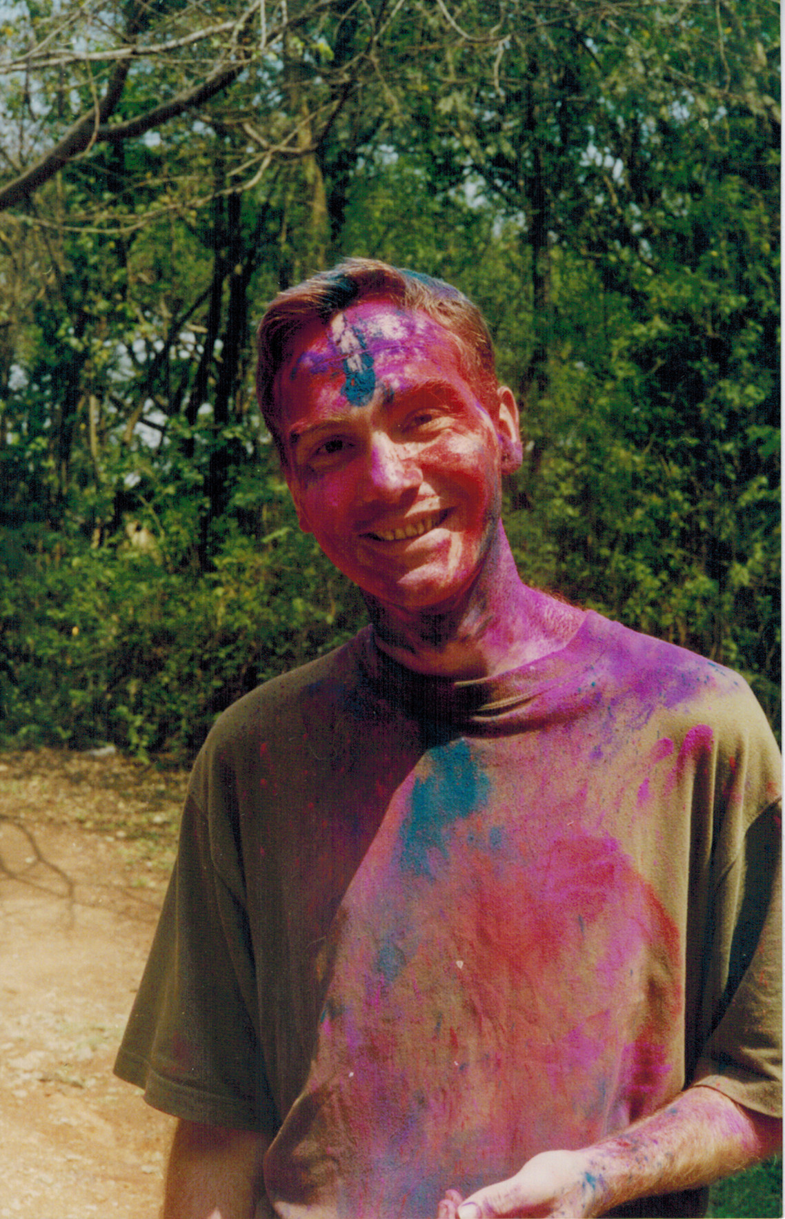Ralph Lano outdoors during Holi in Bangalore, covered in bright festival colours.